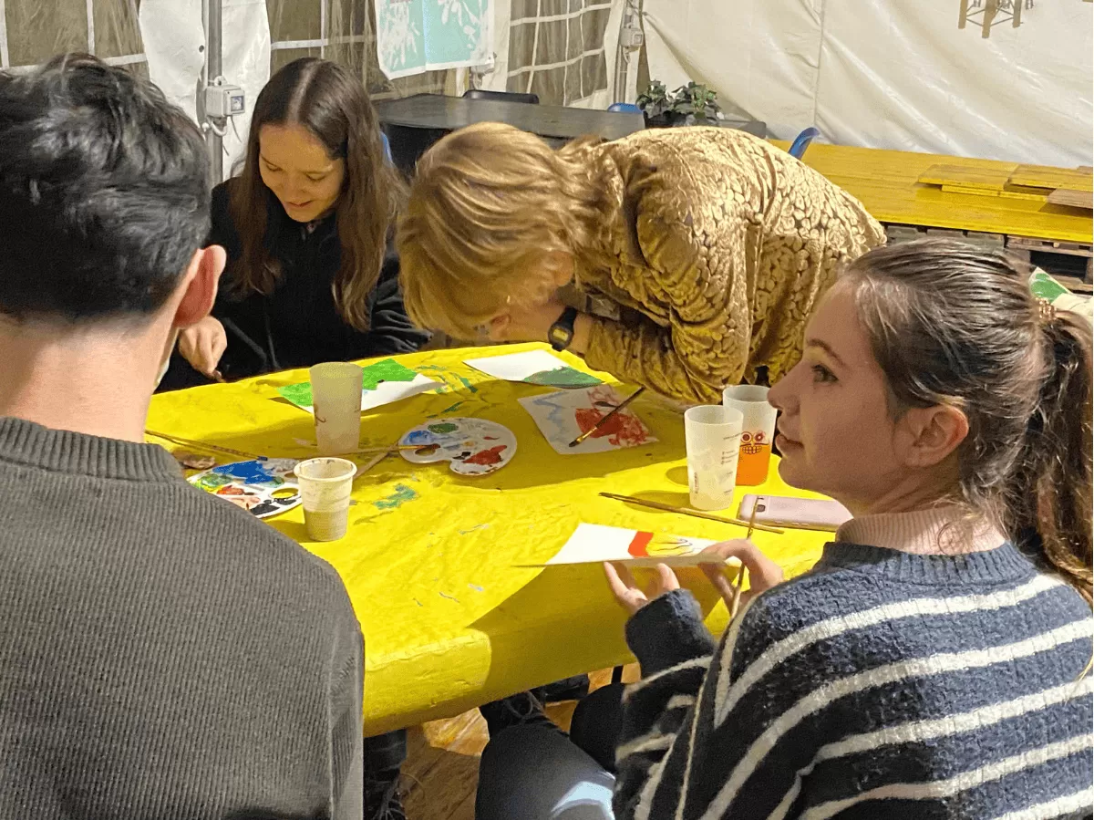 student painting holding the brush between the elbows