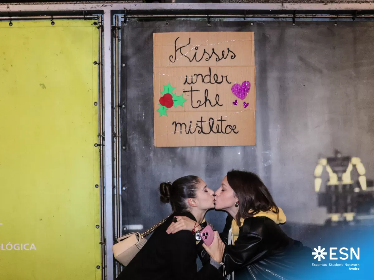 International students sharing a kiss under the mistletoe.