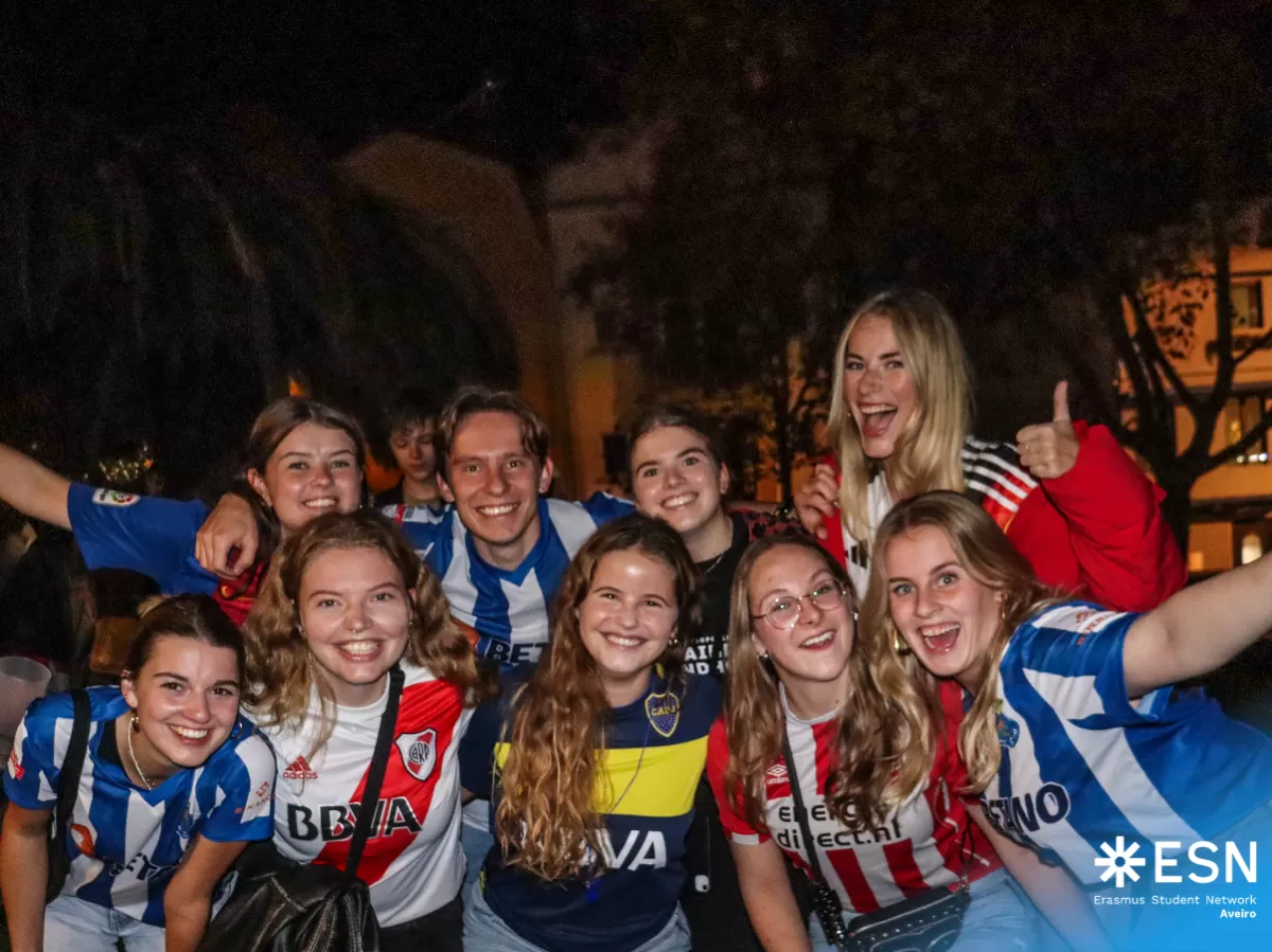 Photo group of international students with football shirts at night.