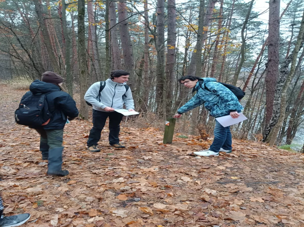 Three participants finding a spot, having a map in their hand