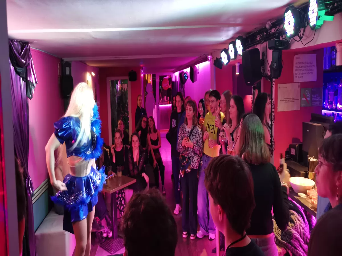 Group of people enjoying the performance of a drag queen indoors