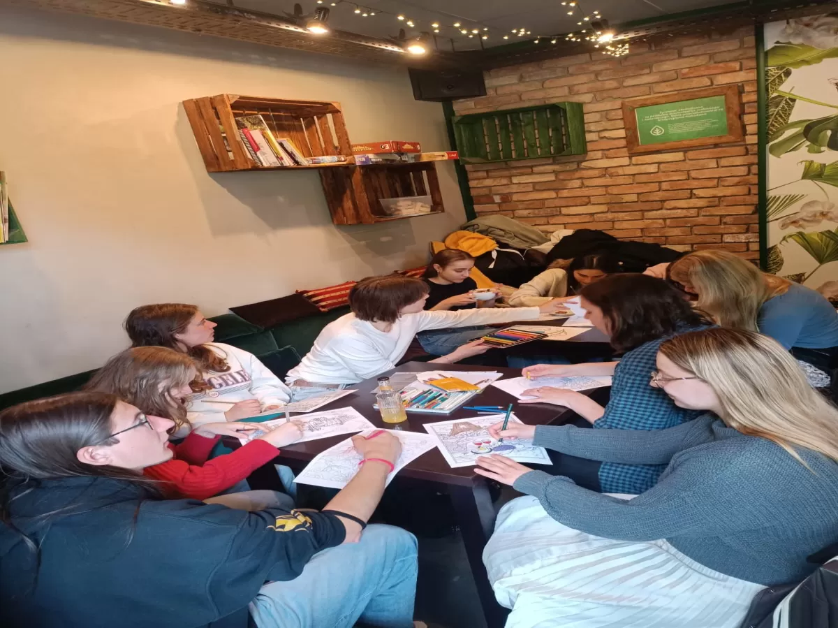 Group of international students colouring in a coffee shop