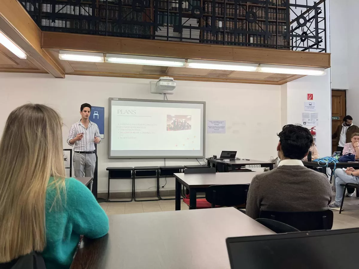 a person giving a speech, a few people sitting before him and listening