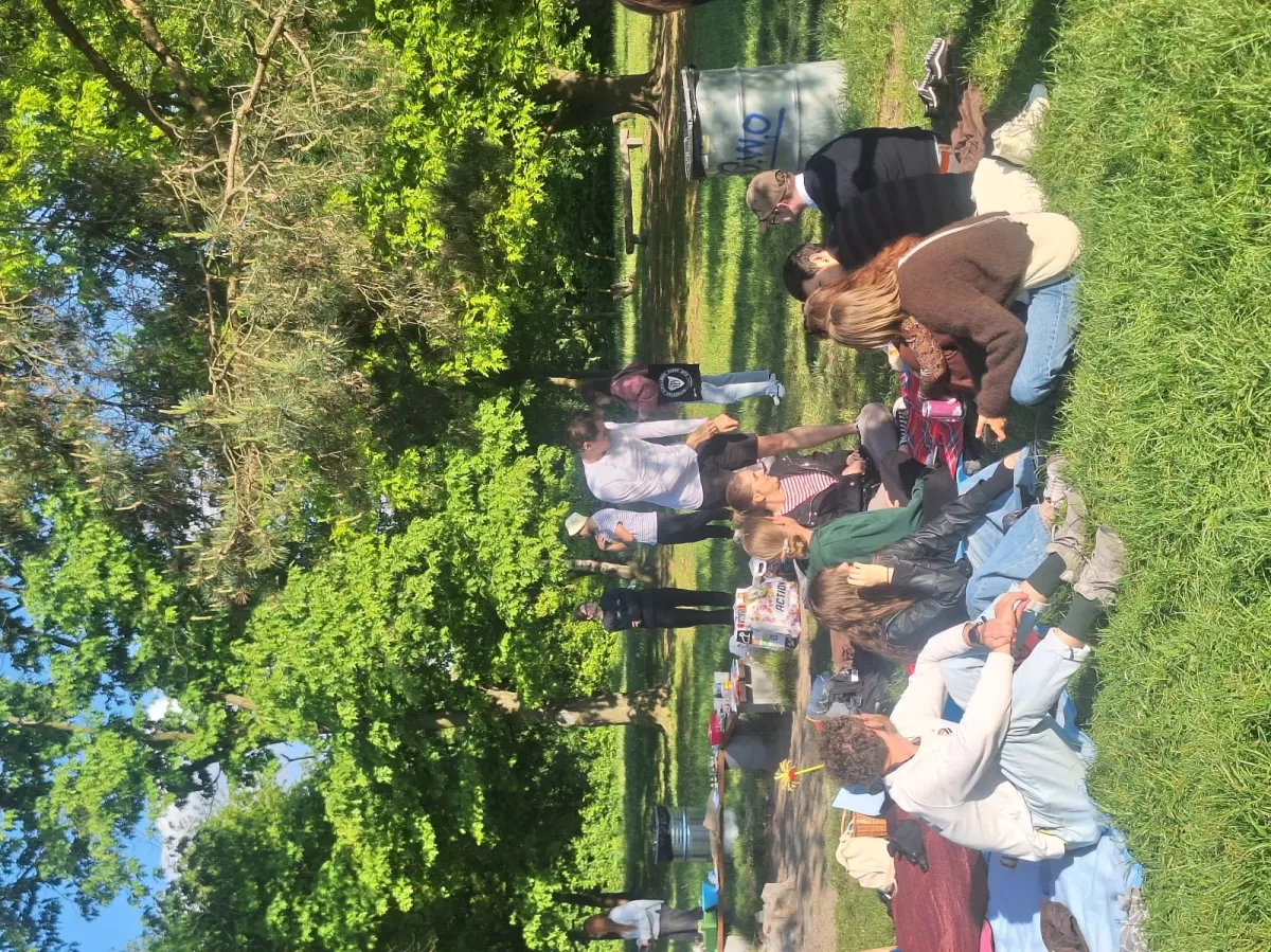 participants enjoying the international dishes among each other and chilling on blankets in nature