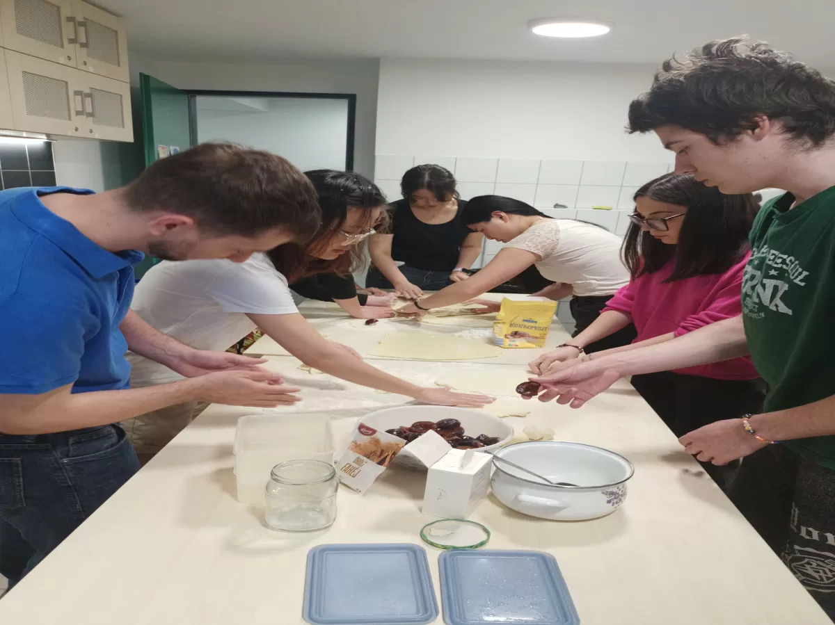 people forming plum dumplings on a long table
