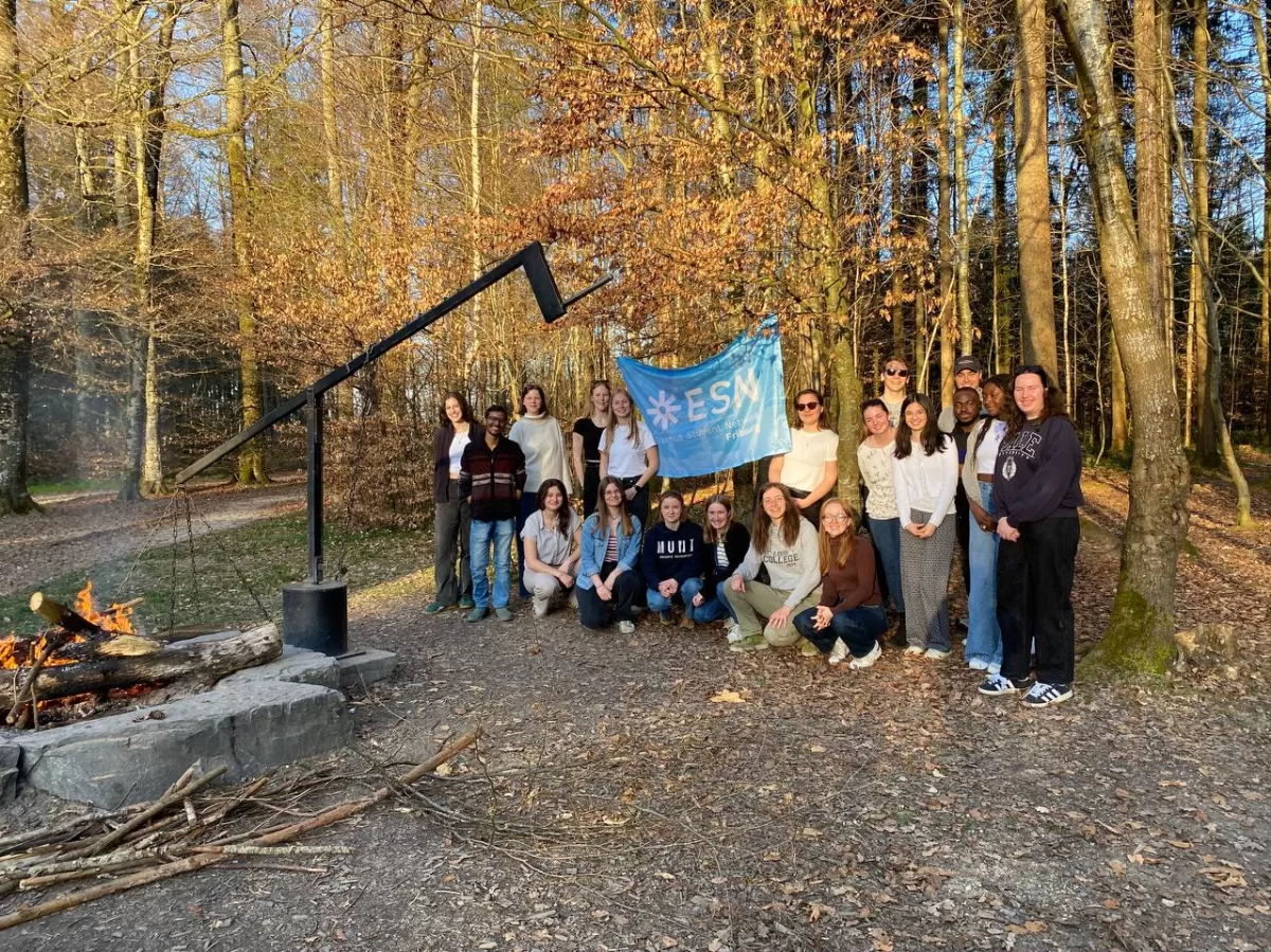 A picture of the students who joined the activity in the forest with the ESN Fribourg flag.