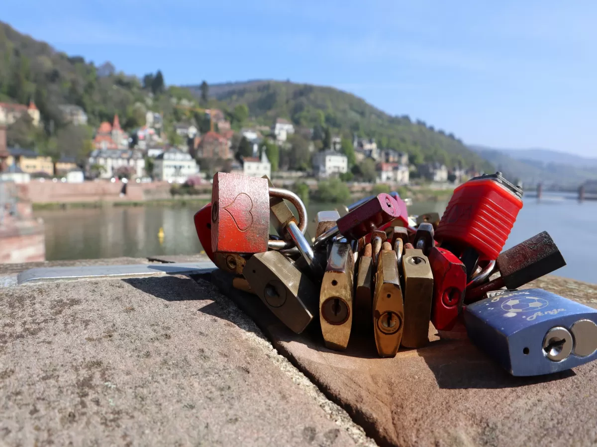 In the background the Neckar river and in foreground a bunch of lockers tied with a string on a bridge