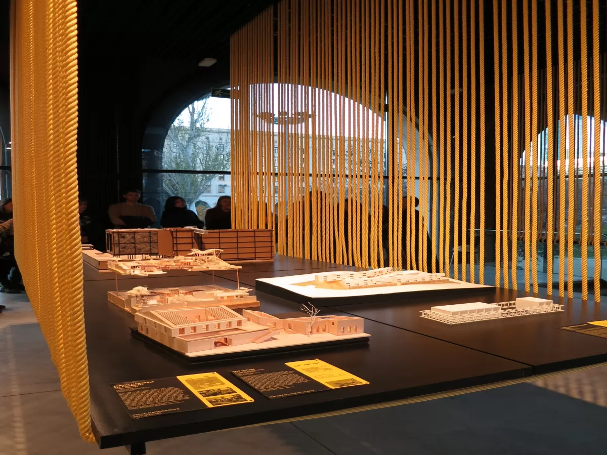 Architecture models at the front and people listening to the museum guide at the background