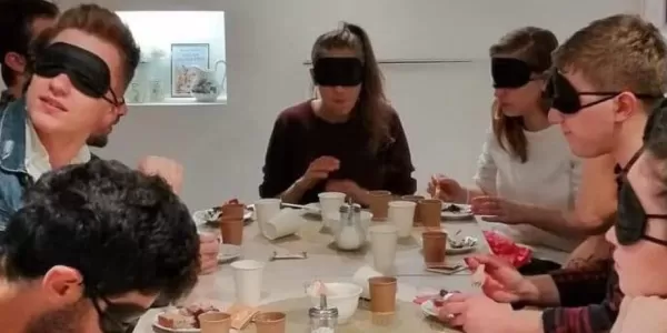 Group of people with something on their eyes to simulate being visually impaired.