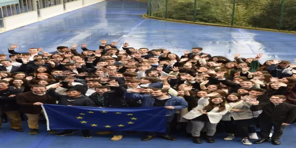 Group of local students, international students and coordinators holding an EU flag
