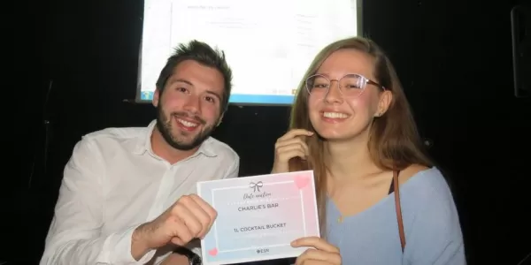 a guy and a girl holding a coupon for their date