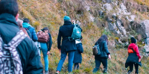 A line of people hiking along a mountanous path