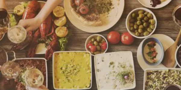 a table with people enjoyng food and drinks