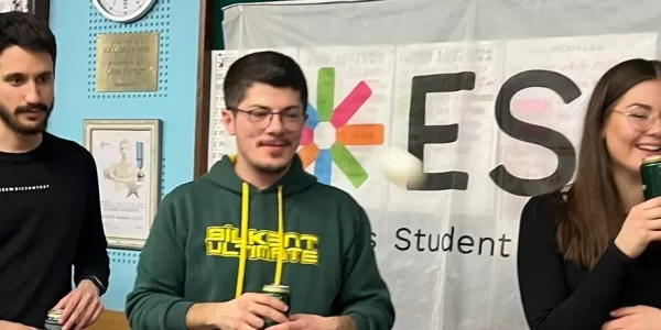 A group of International Students socialising at a fundraising event (with ESN Modena Flag)