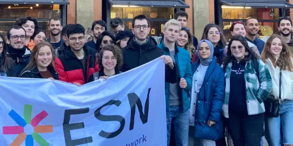 group of international students posing with the ESN Modena flag