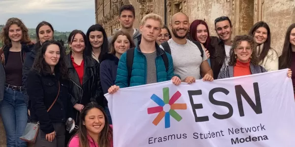 International students posing with the Flag of ESN Modena on the balcony of the Ducal Palace of Sassuolo