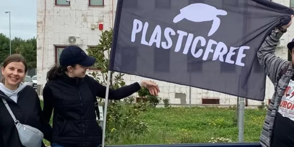 International students posing with the Plasticfree flag