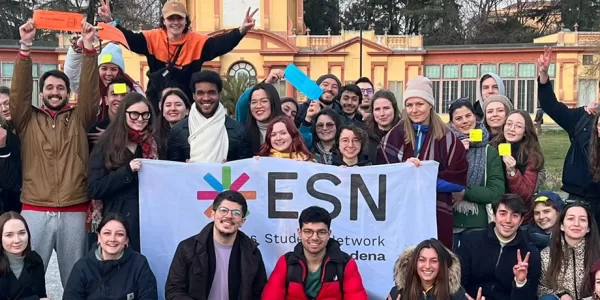 group of international students posing with the ESN Modena flag in Giardini Ducali in Modena