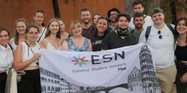 International students holding the flag of ESN Pisa.