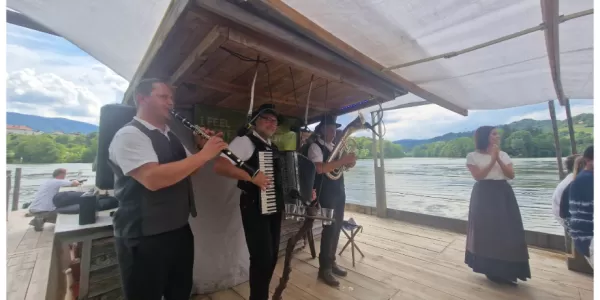 folklore group playing music on the timber raft on the river