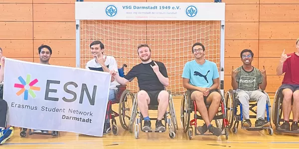Picture of some of the participants posing in their wheelchairs in front of the hanball goal.
