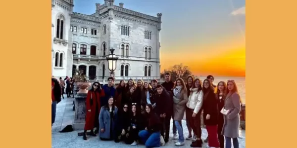 International students and ESN volunteers in front of the Miramare Castle at sunset