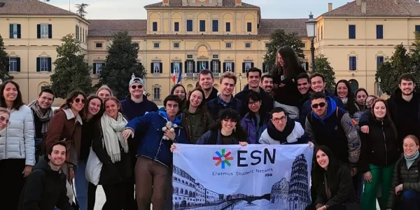 The group of international students who partecipated standing in front of Palazzo Ducale del Giardino in Parma, with the flag of ESN Pisa in the front