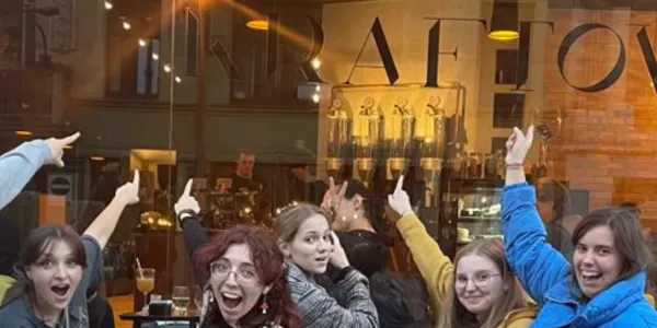 A group of international students in front of a coffee shop
