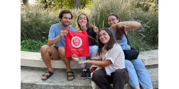 The four winners of the Treasure Hunt sit while showing the bag of the University