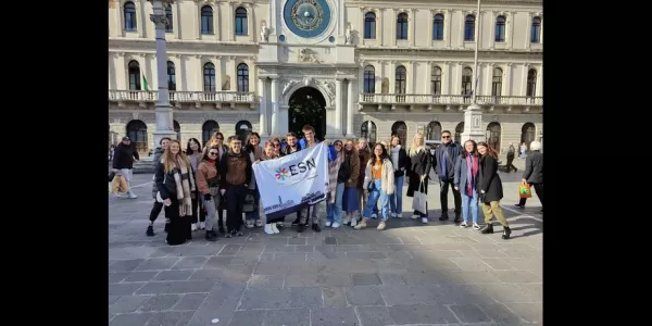 Volunteers and international together holding the flag of ESN Venezia for a group picture in one of the squares in Padova
