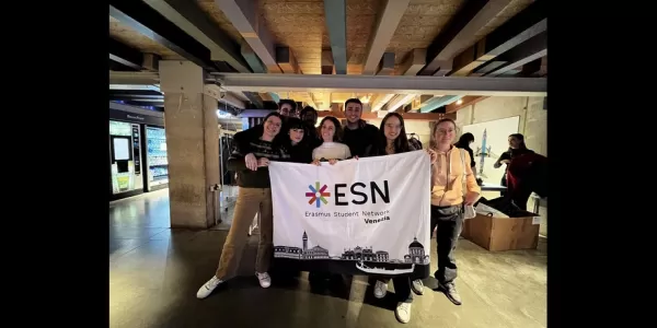 Group picture of the volunteers and the international students holding the ESN Venezia flag in front of the swapping area