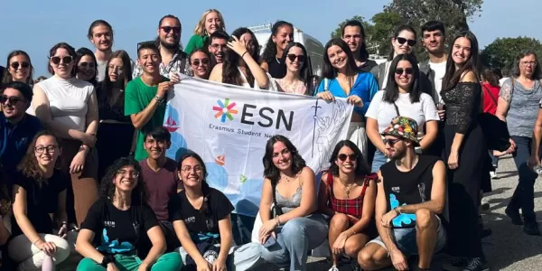 Erasmus students and volunteers in the Strada Napoleonica holding ESN Trieste's flag