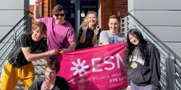 The image shows a group of the participants of the event holding the ESN-EYE flag and water balloons.