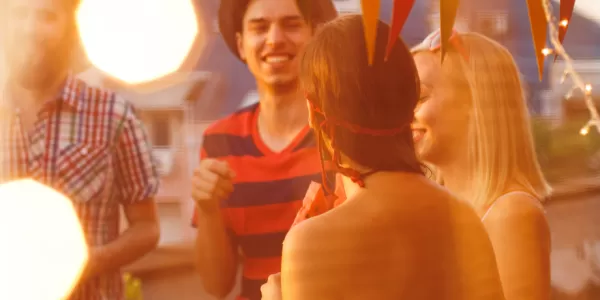 People talking to each other in the rooftop of a building while enjoying the sunset