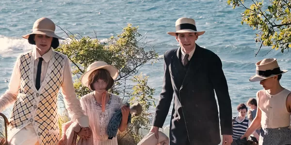 A family of 4 dressed in fancy clothes walking uphill from what looks like Italian coastline