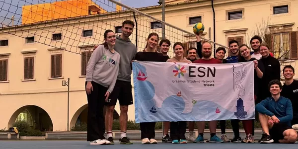 Erasmus students and volunteers on the court with the section's flag