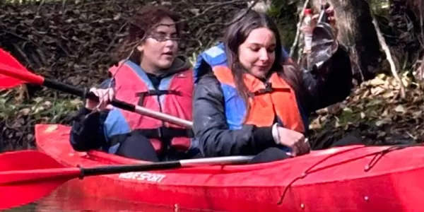 Two participants collecting trash from the river