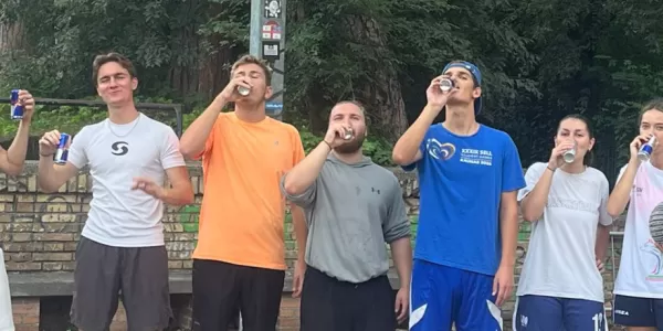 A group photo showing people in basketball gear holding cans of Red Bull