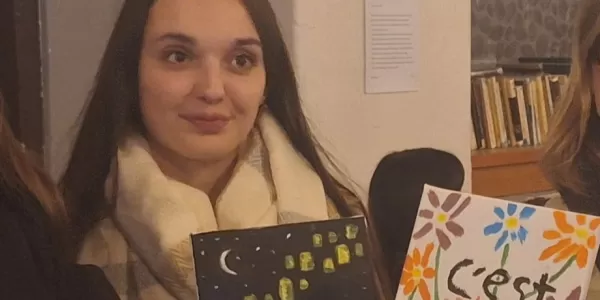 three participants showing their artworks