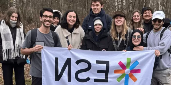 A group of students holding an ESN UŁ flag.