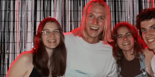 People posing with a black and white decoration in the back