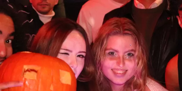 People in the Halloween party with a pumpkin