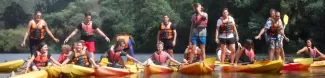 International students posing on top of their kayaks.