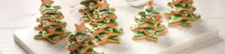 A picture with christmas biscuit in the shape of christmas trees with a tiny biscuit star at the top