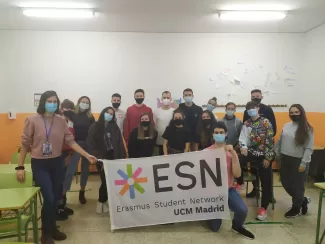 A group of 11 local students with 3 ESNrs and 4 Erasmus stand holding the ESN flag