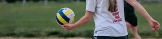 Female student playing volleyball.
