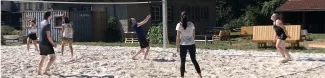 A group of people playing beach volleyball