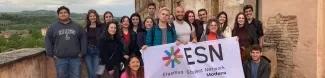 International students posing with the Flag of ESN Modena on the balcony of the Ducal Palace of Sassuolo