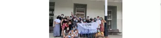 Group of students looking at the camera (with masks on) and with an ESN Barcelona UPF flag.