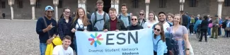 group of international students posing with the ESN Modena flag